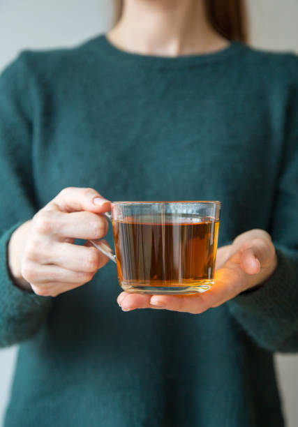 istock Transparent tea cup in woman's hand 1189760398
