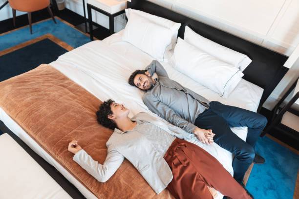 coppia in luna di miele rilassante sul letto - exhaustion tired men after work foto e immagini stock