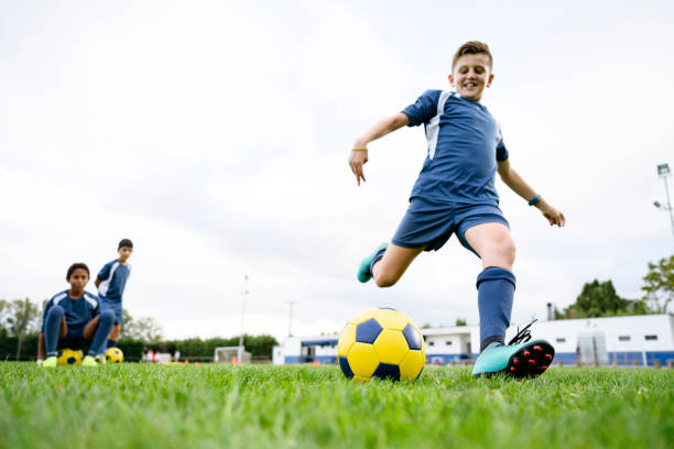 istock Smiling 11 year old footballer practicing stationary kick 1189767785