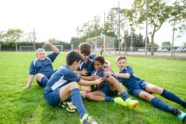 triumphant young male footballers on ground in celebration - soccer celebration success group of people imagens e fotografias de stock