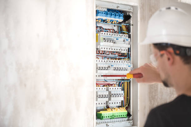 istock Man, an electrical technician working in a switchboard with fuses. Installation and connection of electrical equipment. 1189768220