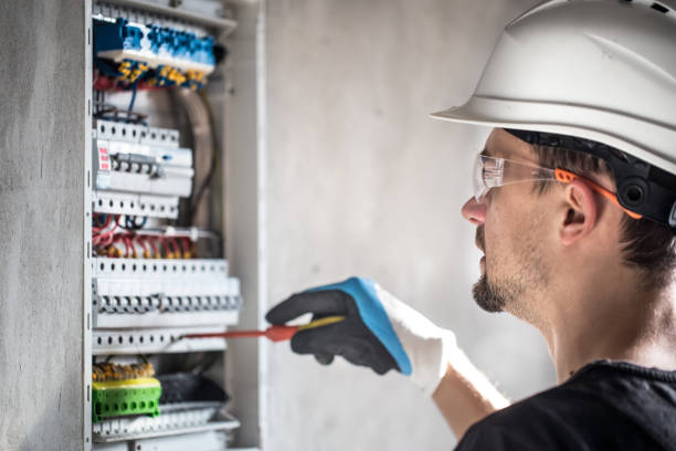 istock Man, an electrical technician working in a switchboard with fuses. Installation and connection of electrical equipment. 1189768224