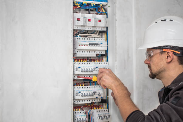 istock Man, an electrical technician working in a switchboard with fuses. Installation and connection of electrical equipment. 1189768232