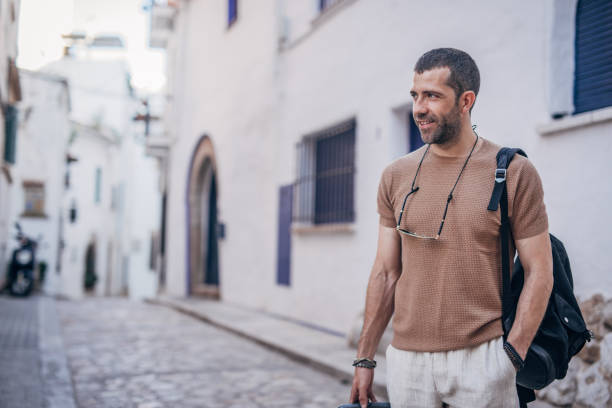 istock Man with luggage standing on the street 1189770733