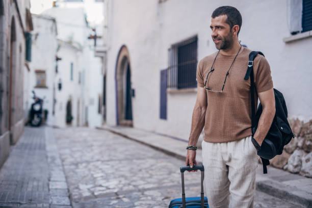 istock Man with luggage standing on the street 1189770758