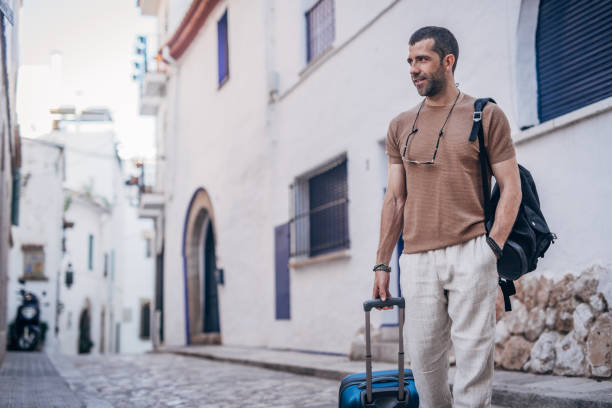 istock Man with luggage standing on the street 1189770771
