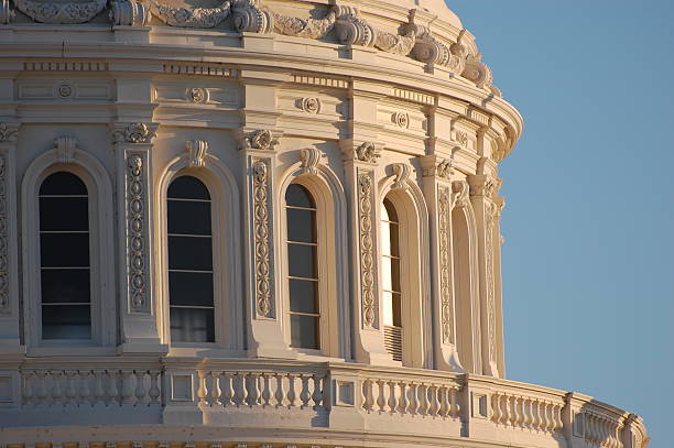 A front view of the US Capitol building's dome, with the American flag.