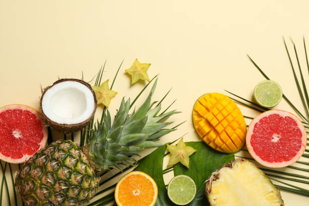 istock Exotic fruits and palm leaves on beige background, space for text 1189774012