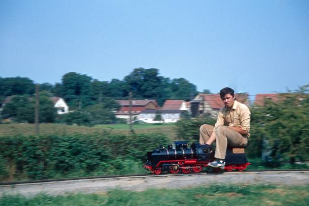 Hesse (exact location unfortunately not known), Germany, 1978. Hobby ironman drives a lap on a miniature locomotive.