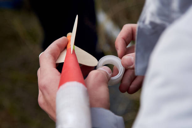 The guy holds in his hands a model of a rocket and prepares it for flight. The guy holds in his hands a model of a miniature rocket and prepares it for flight. model rocket stock pictures, royalty-free photos & images