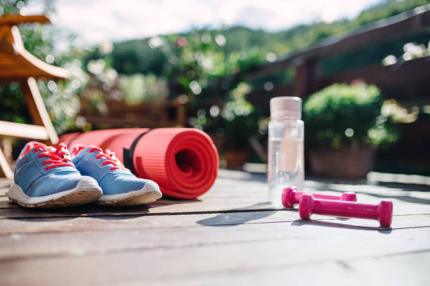istock Water bottle, trainers and dumbbells outdoors on a terrace in summer. 1189775068