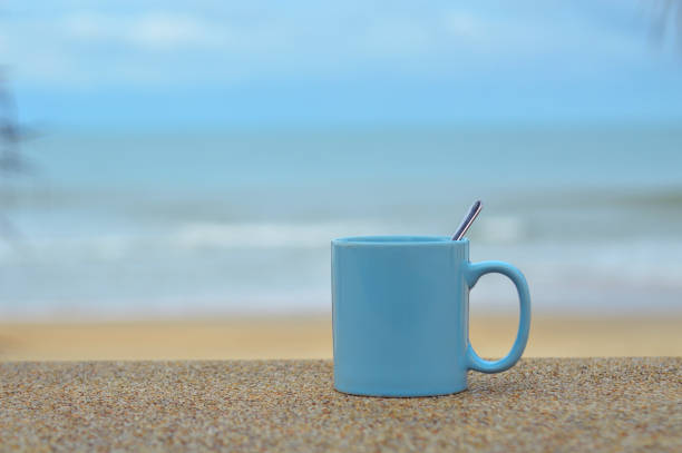 blue cup on the beach with blue sea and sky
