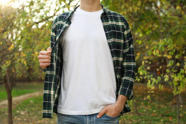Men in white t-shirt and checkered shirt in park, copy space