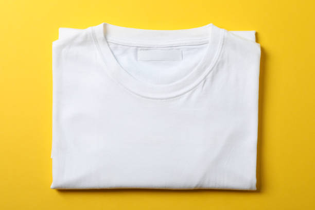 istock Folded blank white t-shirt on yellow background, space for text 1189776649