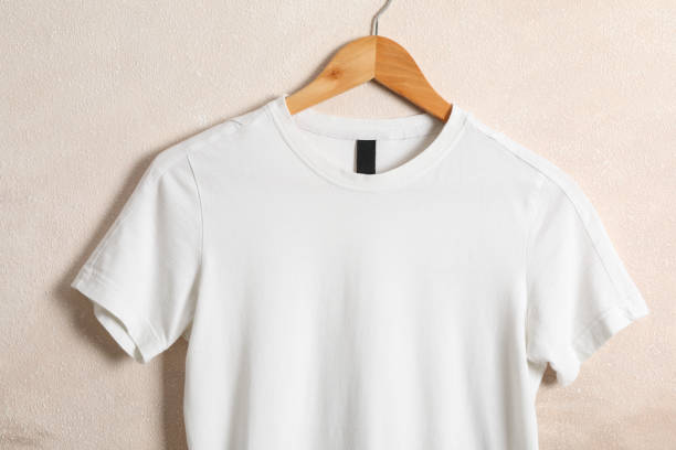 istock Hanger with blank white t-shirt on light brown background, space for text 1189776763
