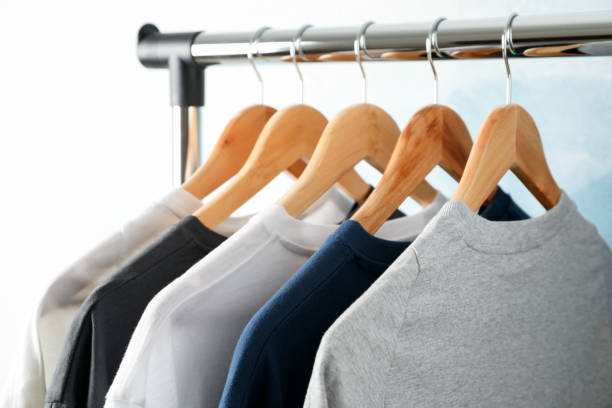 istock Rack with blank t-shirts on blue background, space for text 1189777046
