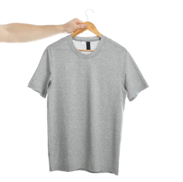 istock Man holds a hanger with blank t-shirt, isolated on white background 1189777156