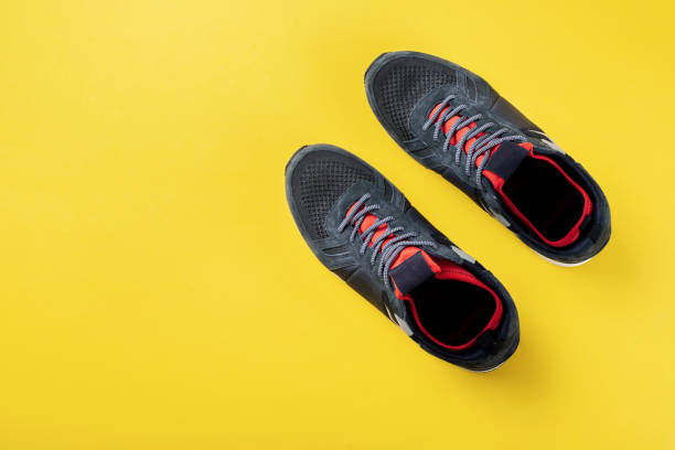 istock men's sneakers on a bright yellow background. place for text 1189778054