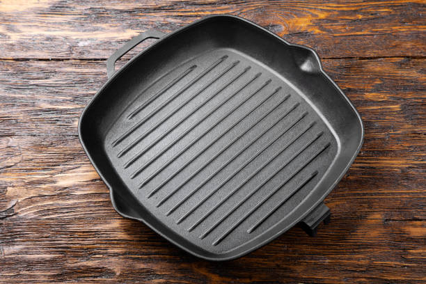 istock New cast-iron grill pan on a wooden background. 1189778166