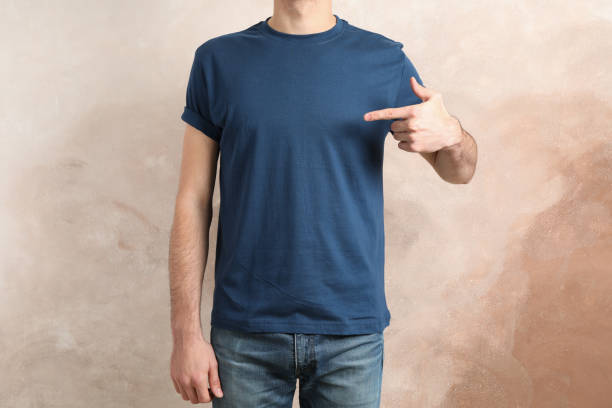 istock Men in blank blue t-shirt against brown background, space for text 1189778238