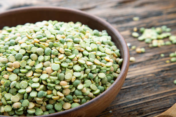 pois verts secs sur une plaque d'argile sur la table. - textured nobody close up seed photos et images de collection