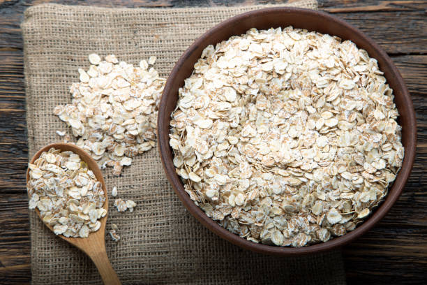 istock raw oatmeal in a spoon and in a plate on the table. 1189778242