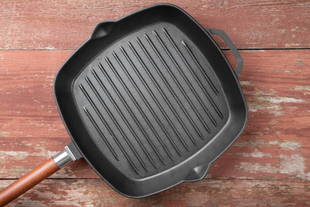 istock New cast-iron grill pan on a wooden background. 1189778245