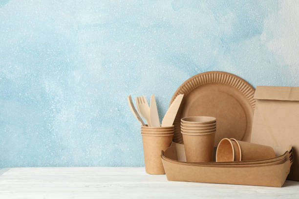 istock Eco - friendly tableware and paper bag on wooden table, space for text 1189778752