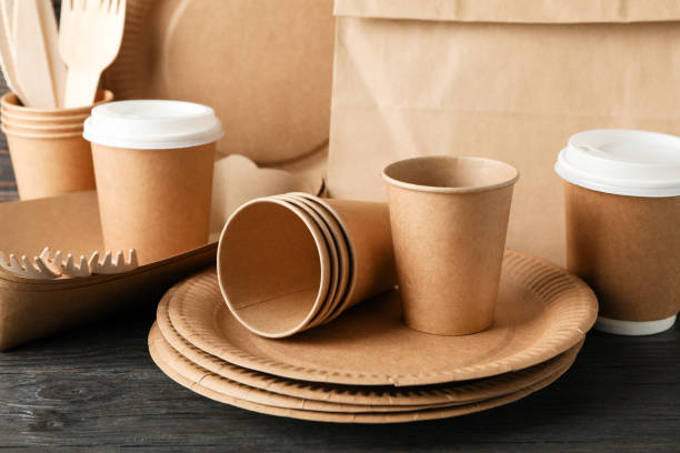 istock Eco - friendly tableware and paper bag on wooden table, close up 1189778970