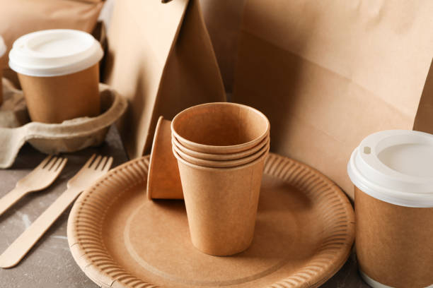 istock Eco - friendly tableware and paper bag on grey table, close up 1189780045