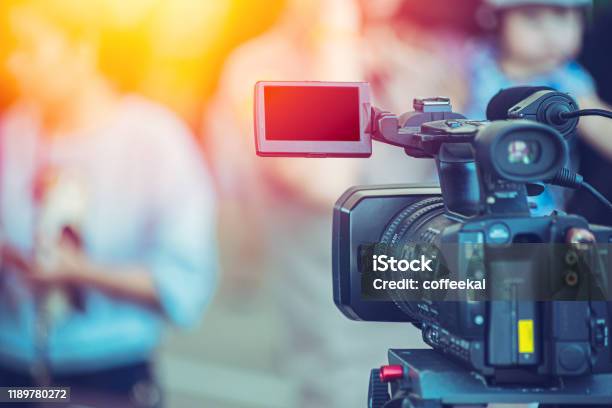 Video Camera Camcorder Operator Working At Live Event Broadcasting Blue Color Tone Stock Photo - Download Image Now