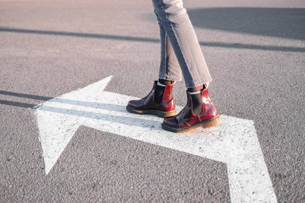 istock Feet walking along the left turn sign. 1189780746