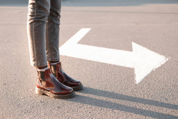 feet standing beside a right turn sign. - turning point imagens e fotografias de stock