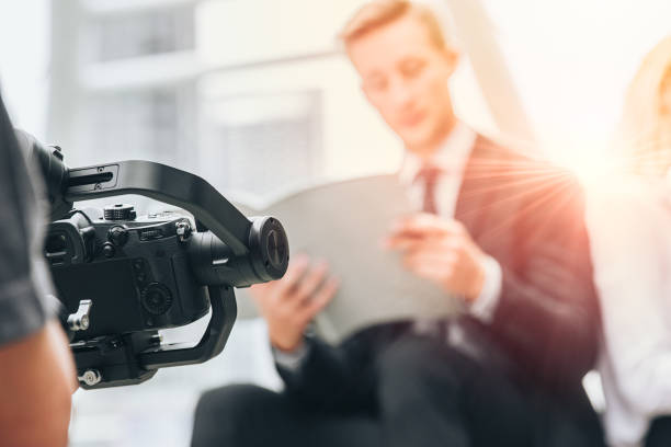 istock Videographer professional shooting record video usign gimbal camera stabilizer for anti shake device technology in businessman scene. 1189781478