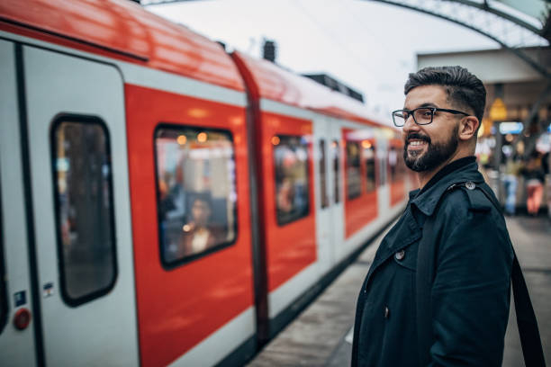 istock Young man standing at train station 1189781537