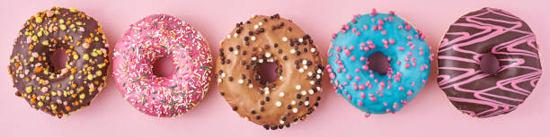 istock Different types of a colorful donats decorated sprinkles and icing on blue background, long banner 1189781550
