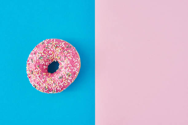 istock donut on a pastel pink and blue background. Minimalism creative food composition. Flat lay style 1189781556