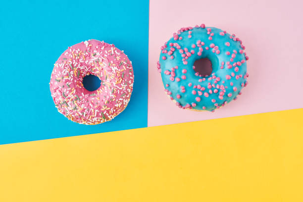 istock Donuts on a pastel pink, yellow and blue background. Minimalism creative food composition. Flat lay style 1189781559