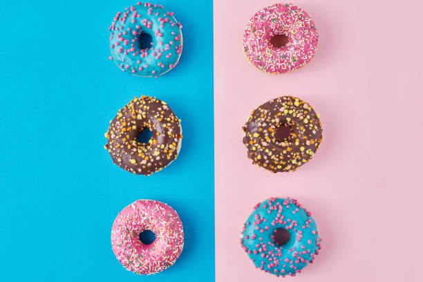 istock Donuts on a pastel pink and blue background. Minimalism creative food composition. Flat lay style 1189781575