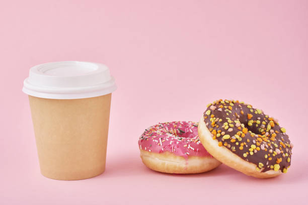 istock Cup of coffee and donuts on a pink background 1189781593