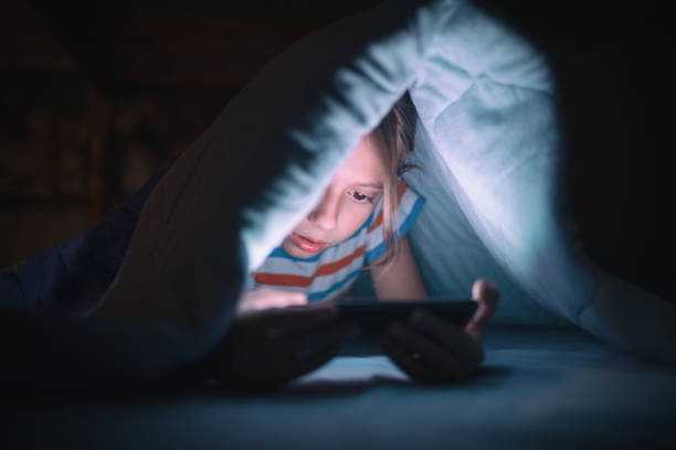 istock Boy playing games on mobile phone in his bed 1189781700