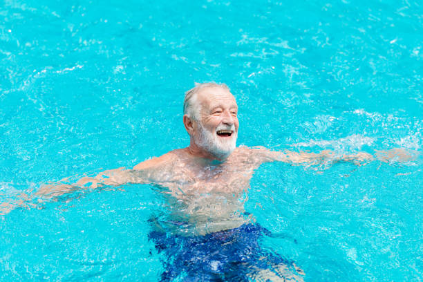 Healthy elder happy enjoy and laugh in the swimming pool in the summer season. Healthy elder happy enjoy and laugh in the swimming pool in the summer season. lance armstrong foundation stock pictures, royalty-free photos & images