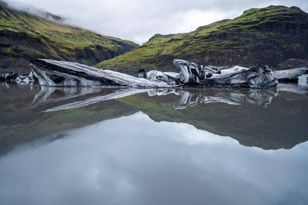 icebergs flottants et leurs reflets dans la lagune du glacier solheimajokull dans le sud de l'islande, entre les volcans katla et eyjafjallajokull. solheimajokull est populaire en raison de sa facilité d'accès. - facilité daccès photos photos et images de collection