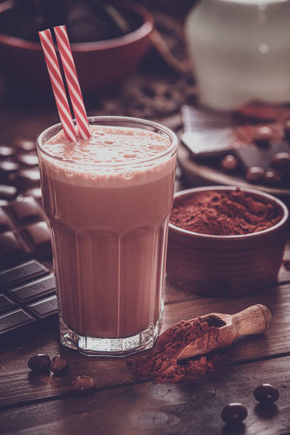 istock Chocolate milkshake and ingredients on rustic wooden table. Retro style 1189783997