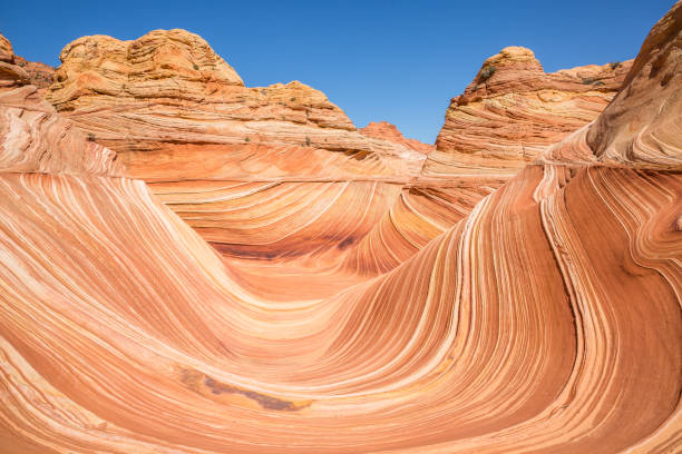 Perfect sunlight coverage of The Wave in North Coyote Butte, Arizona. Perfect blue sky and full sun on The Wave in North Coyote Buttes, Arizona. the wave arizona stock pictures, royalty-free photos & images