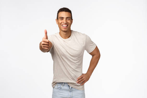 istock Sounds good, nice work, keep up. Optimistic handsome young hispainic muscline guy, wear casual t-shirt, show thumbs-up and smiling in approval, accept something, like product, recommend advertise 1189791160