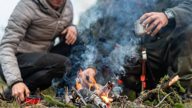 istock Man and woman preparing tea using fire in the wilderness 1189793892