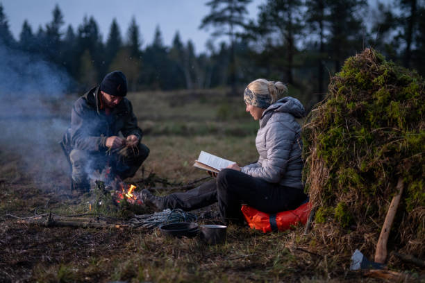istock Couple sitting next to a campfire 1189793900