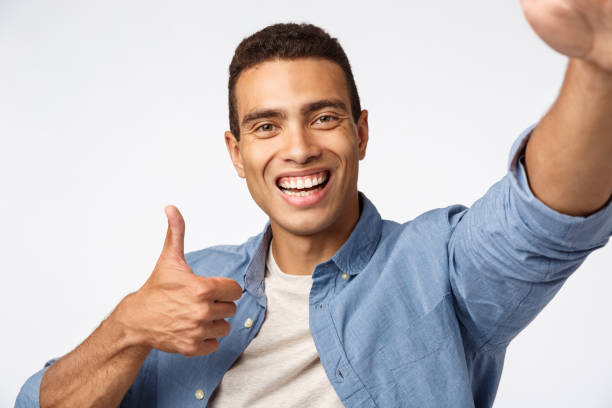 istock Cheerful supportive boyfriend encourage girlfriend as talking video-call, holding device with stretched hand, touch camera, make thumbs-up in approval or like, smiling satisfied, white background 1189795876