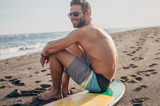 Ocean waves, senior man surfing on beach and healthy fitness lifestyle in Australia summer holiday. Elderly surfer swimming with surfboard, sea water exercise and relax in retirement travel vacation